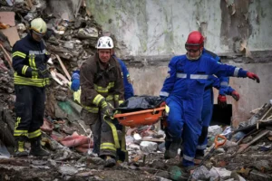 Рятувальники виносять тіло загиблого з-під завалів у Дарницькому районі Києва після обстрілу