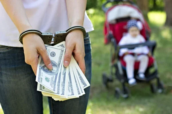 Засуджений за продаж немовляти тримає долари в наручниках біля коляски