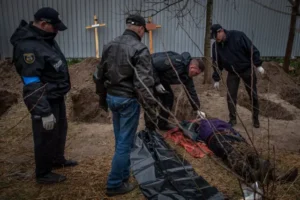 Слідчі оглядають тіло жертви катувань у Бучі під час ексгумації
