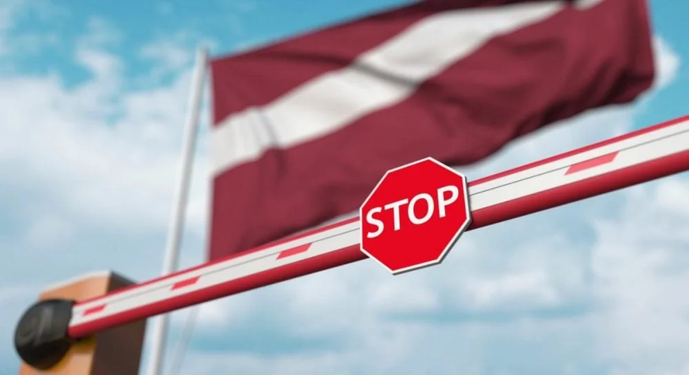 Латвійський прапор за шлагбаумом STOP як символ спротиву РФ