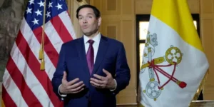 Марко Рубіо виступає на тлі прапорів США та Ватикану перед візитом до Рима
