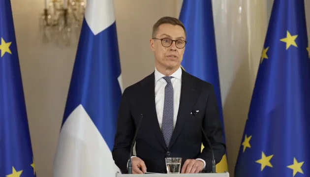 Александер Стубб за трибуною на тлі прапорів Фінляндії та ЄС