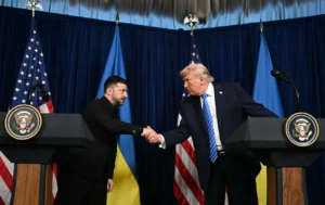 Володимир Зеленський тисне руку Дональду Трампу перед прапорами України та США