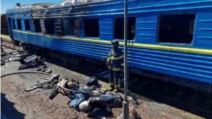 Пошкоджений вагон поїзда Харків-Одеса та рятувальник на колії