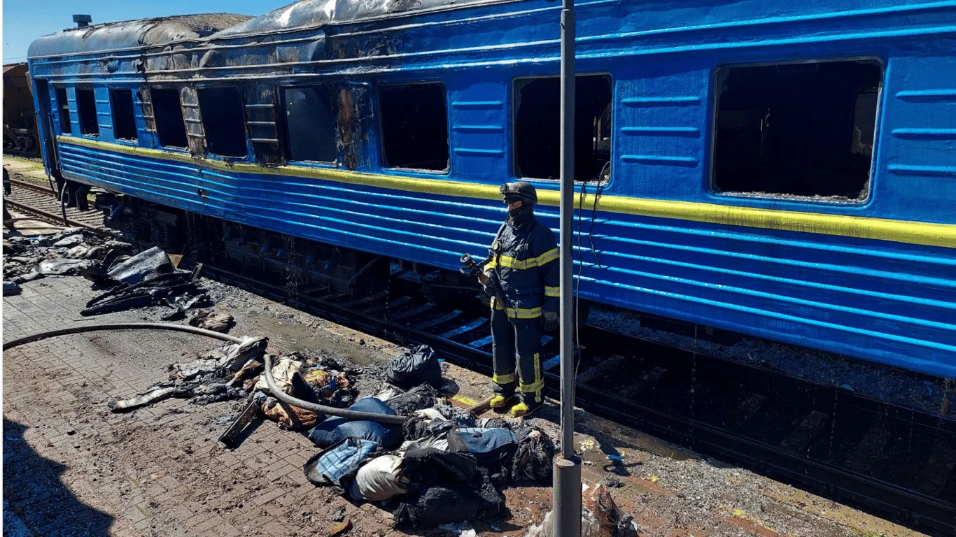 Пошкоджений вагон поїзда Харків-Одеса та рятувальник на колії
