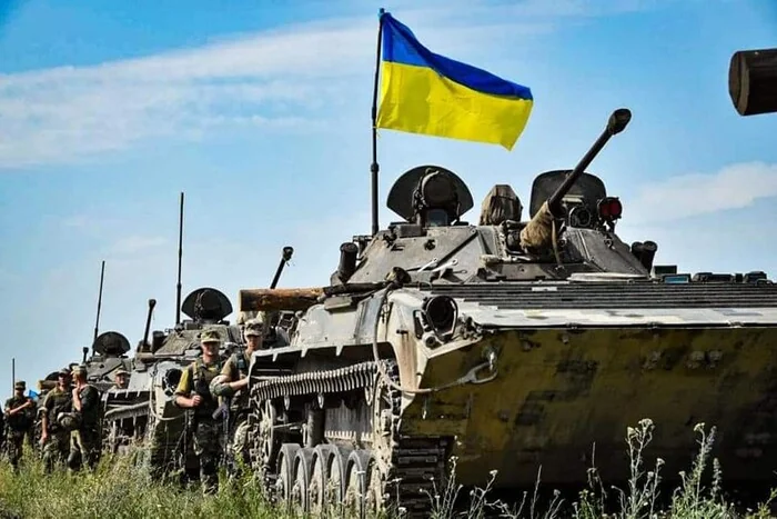 Українські військові з прапором на бронетехніці ЗСУ на Кінбурнській косі