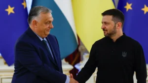 Виктор Орбан и Владимир Зеленский пожимают руки на фоне флагов ЕС и Украины