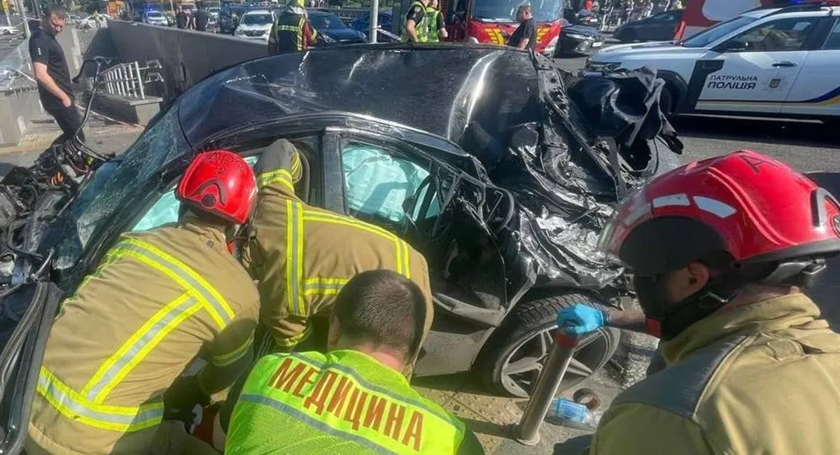 Пошкоджений Mercedes-Benz C300 після смертельної ДТП у Києві з рятувальниками на місці