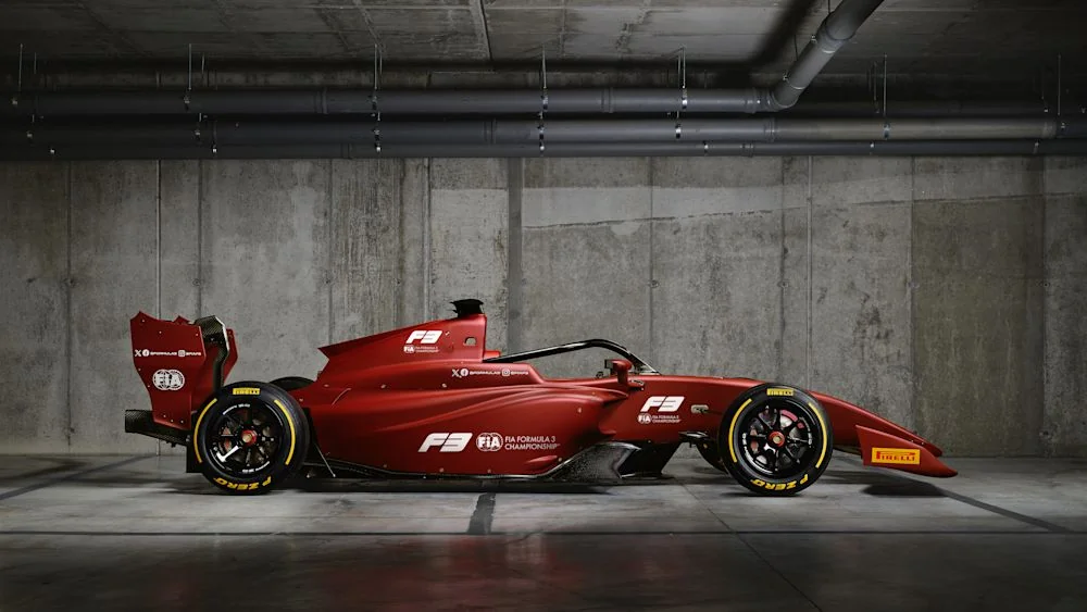 Червоний болід Формули-3 у бетонному гаражі з логотипами Pirelli