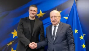 Андрюс Кубилюс и Михаил Федоров жмут руки на фоне флагов ЕС