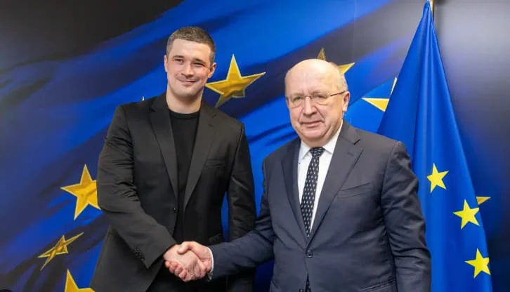 Андрюс Кубілюс та Михайло Федоров тиснуть руки на тлі прапорів ЄС