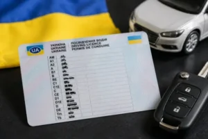 Водительское удостоверение Украины с категориями на фоне флага и ключей авто