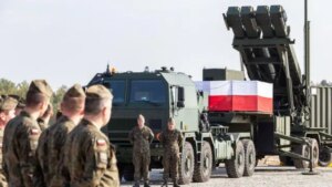 Польські військові біля пускової установки Patriot з прапором країни