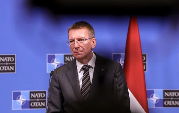 Президент Латвії Едгарс Рінкевичс на тлі прапора та логотипів НАТО