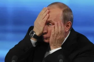 Володимир Путін закриває обличчя руками на тлі падіння рейтингу