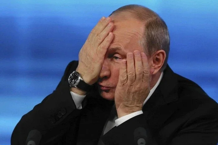 Володимир Путін закриває обличчя руками на тлі падіння рейтингу