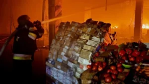 Пожежник гасить пожежу на складі АТБ після удару Росії