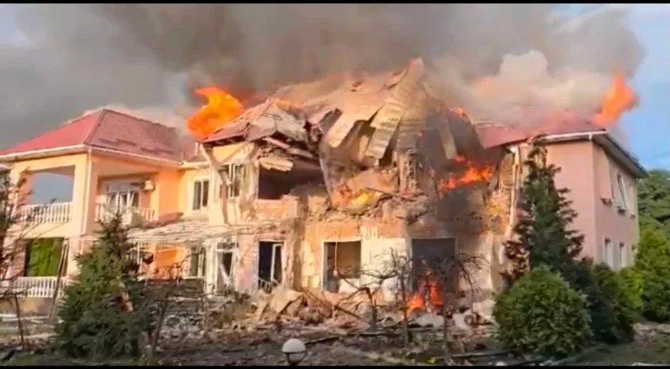 Зруйнований палаючий двоповерховий будинок після удару з густим димом і полумям