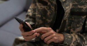 Военнослужащий пользуется смартфоном для е-ВИД в приложении Армия+