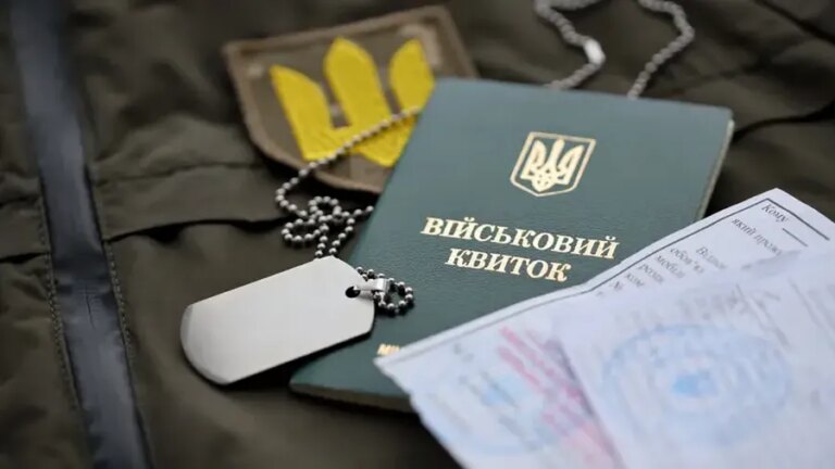 Военный билет, жетоны и трезубец на фоне отсрочки от мобилизации