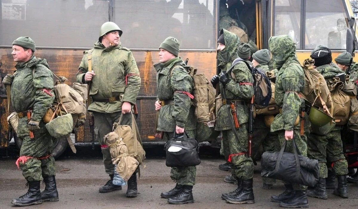 Російські солдати-призовники з багажем біля автобуса під час мобілізації