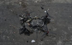 Обгорілий зруйнований ударний дрон на мокрій брудній поверхні